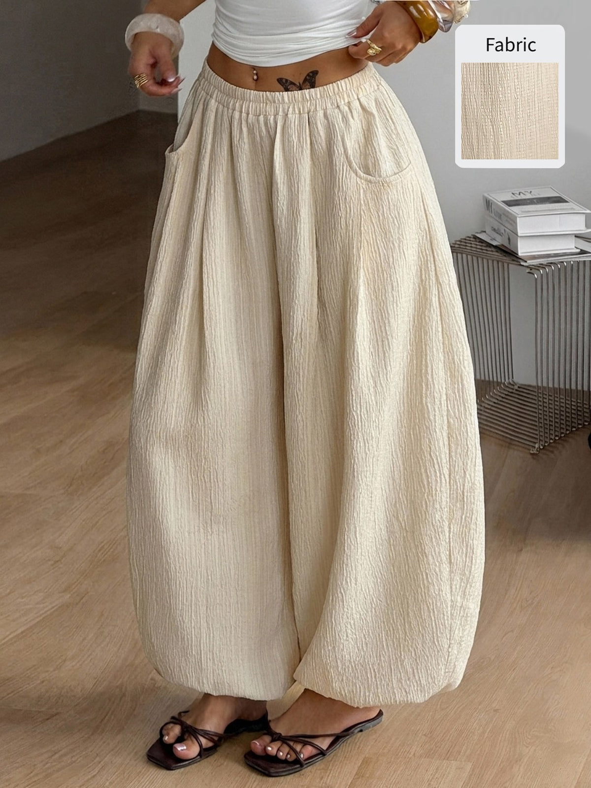 Women's loose-fit black bloomer pants made of 100% cotton featuring an elastic waistband and side pockets.