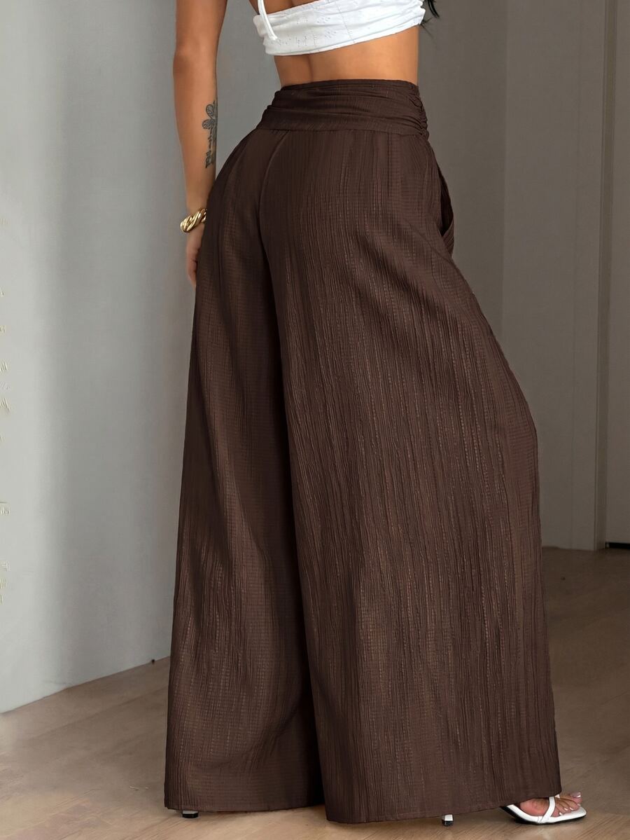 Women's plus size high-waist pleated wide leg pants in textured woven fabric with pockets
