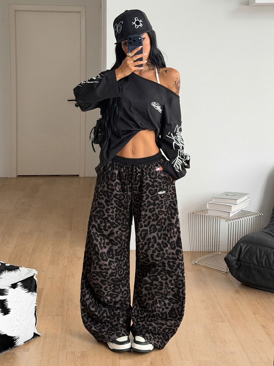 Women's black baggy jogger pants with an adjustable drawstring waist and colorblock polka dot geometric pattern.