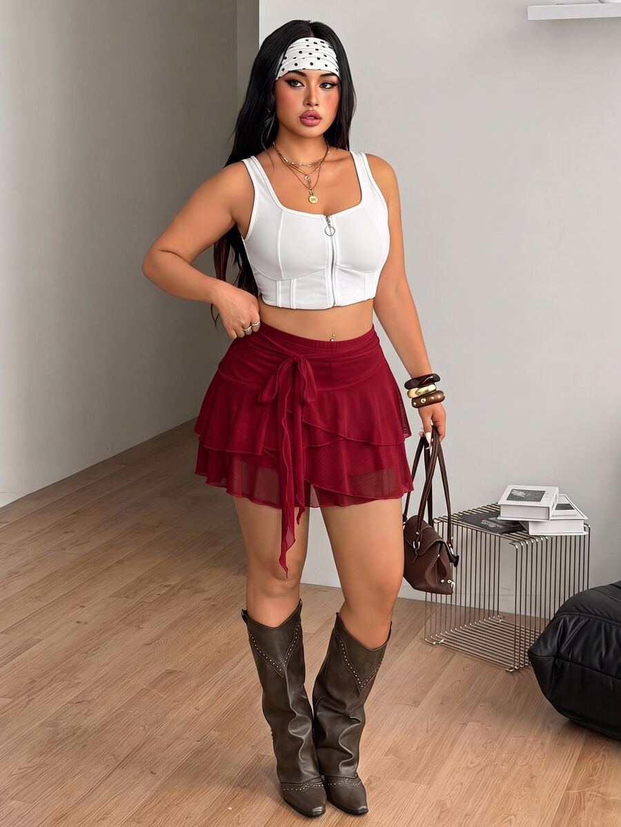 Burgundy tiered pleated mini skirt featuring a mid-waist cut and stretchy knitted fabric.