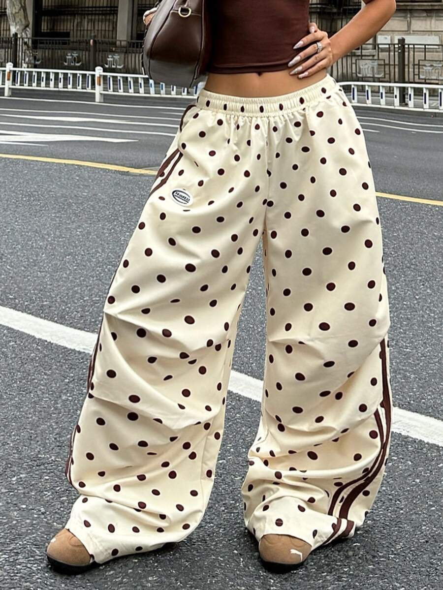 Women's black and white striped wide leg pants featuring an elastic drawstring waistband, side pockets, and a loose straight leg fit.