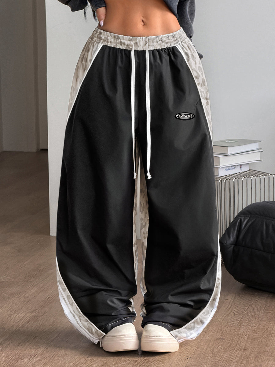Women's loose fit straight leg pants in black and white with banded texture design, low drawstring waist, and pockets.