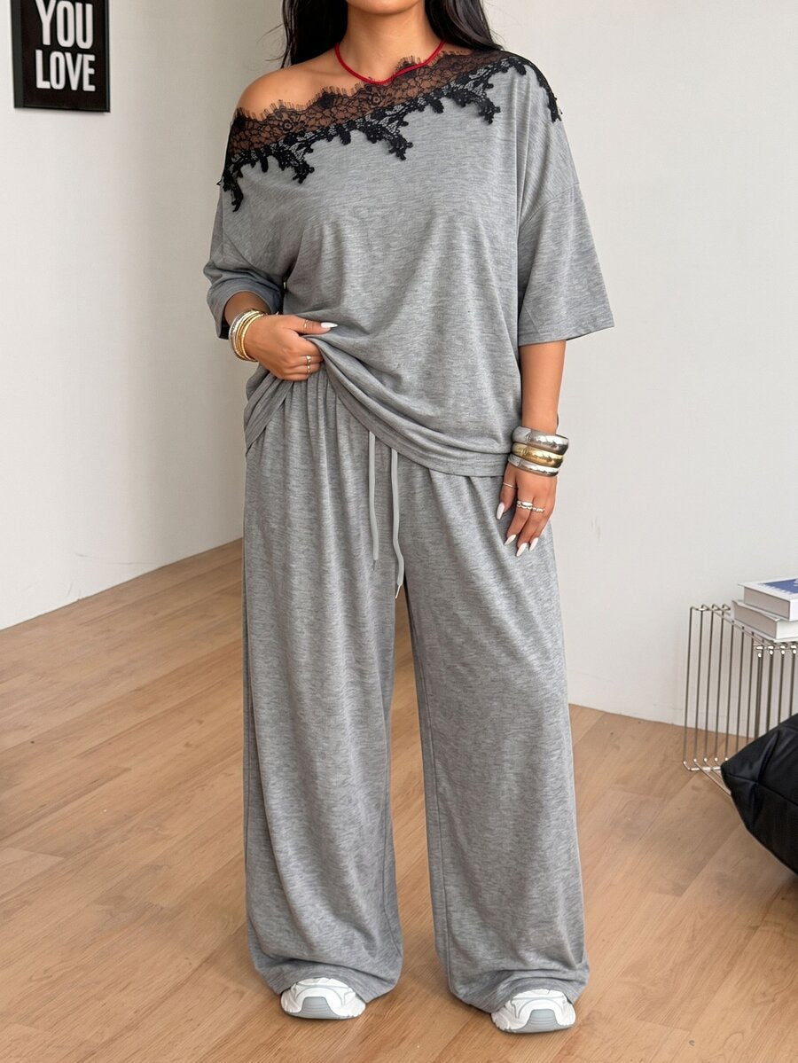 Women's casual two-piece outfit featuring a loose short-sleeve asymmetrical neck t-shirt and matching long wide leg pants with pockets.