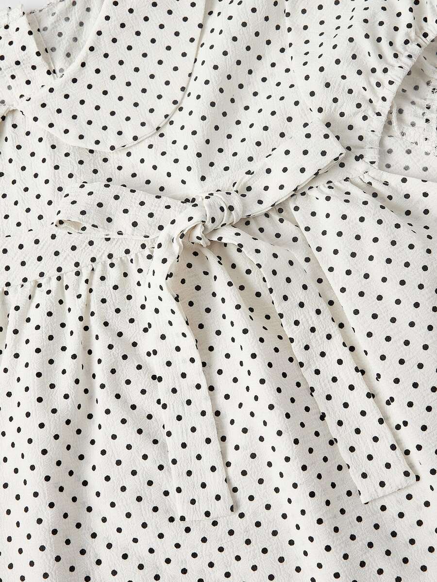 Short sleeve plaid shirt for women featuring a Peter Pan collar with a bow accent, puff sleeves, and a flared hem.