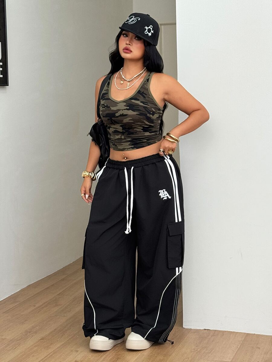 Women's plus size loose straight leg pants featuring a black and white color block design with side stripes and an elastic drawstring waist.