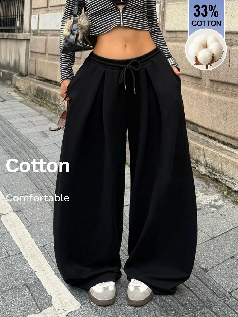 Women's casual black loose fit baggy banana pants featuring a low rise elastic drawstring waist and side pockets.