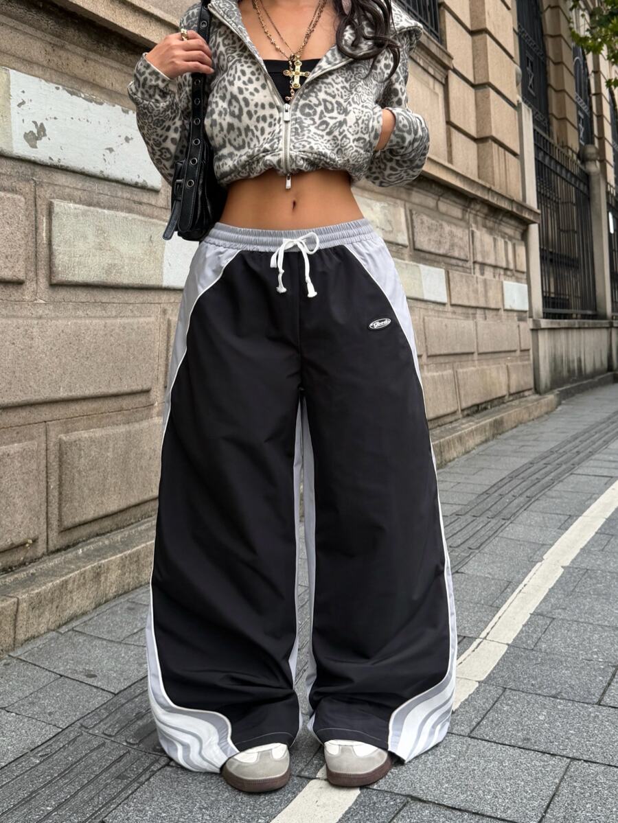 Women's loose fit straight leg pants in black and white with banded texture design, low drawstring waist, and pockets.