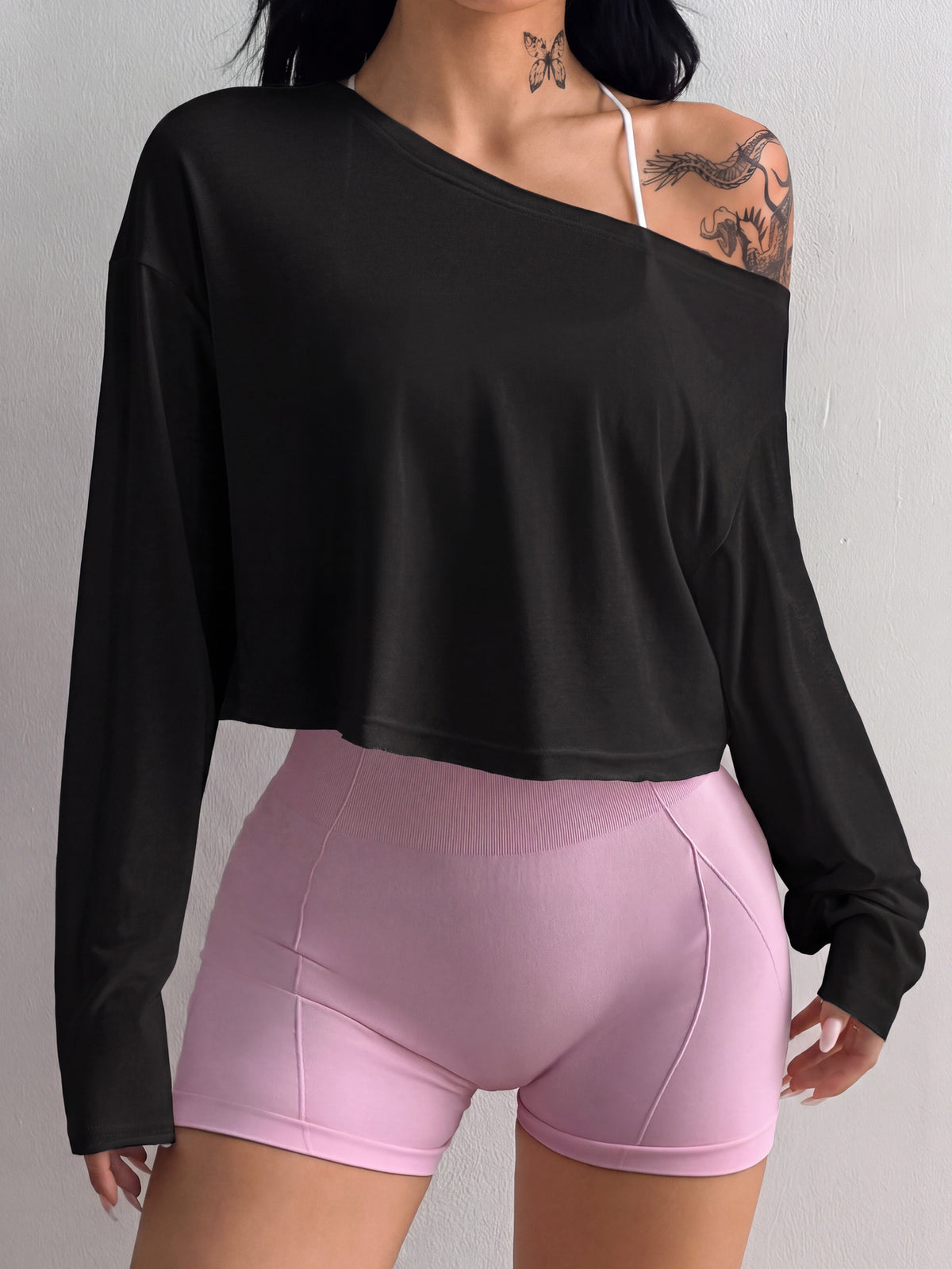 Women's white one shoulder rib-knit crop pullover top featuring an asymmetrical neckline, drop shoulder long sleeves, and a relaxed loose fit for yoga and athleisure wear.