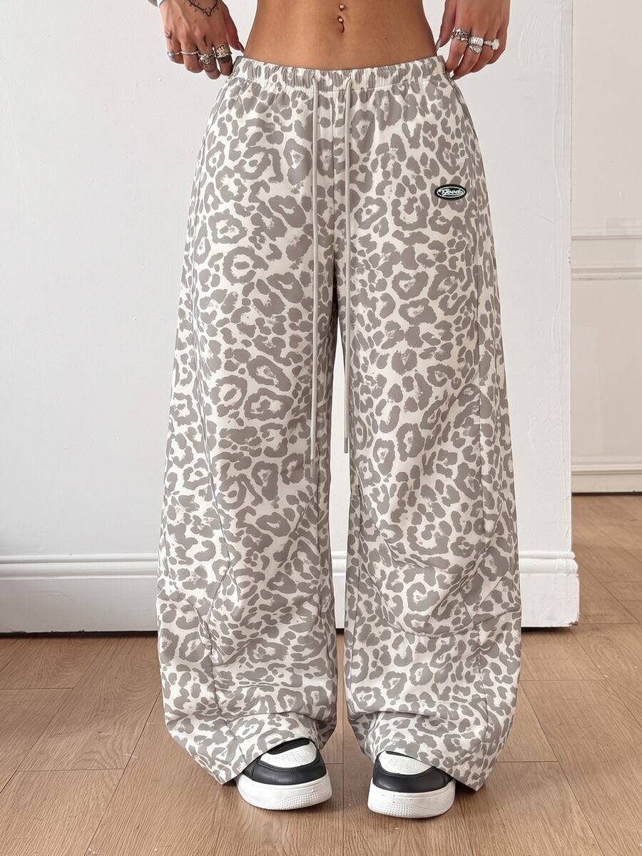 Women's black baggy jogger pants with an adjustable drawstring waist and colorblock polka dot geometric pattern.
