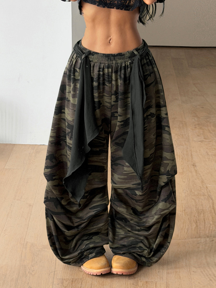 Loose-fitting black baggy parachute pants featuring an elastic drawstring waistband and wide-leg cut made from cotton blend fabric.