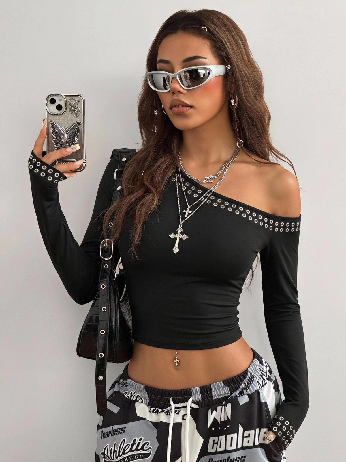 Women's slim fit long sleeve knit top featuring an asymmetrical neckline and grommet eyelet detail