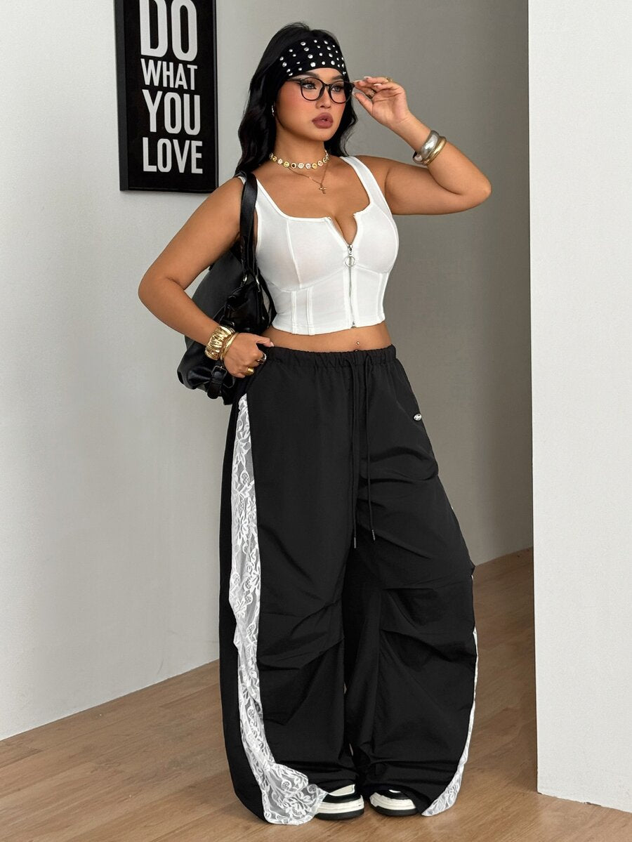 Women's high waist wide leg pants in black featuring leopard print patchwork details and an elastic drawstring waistband.