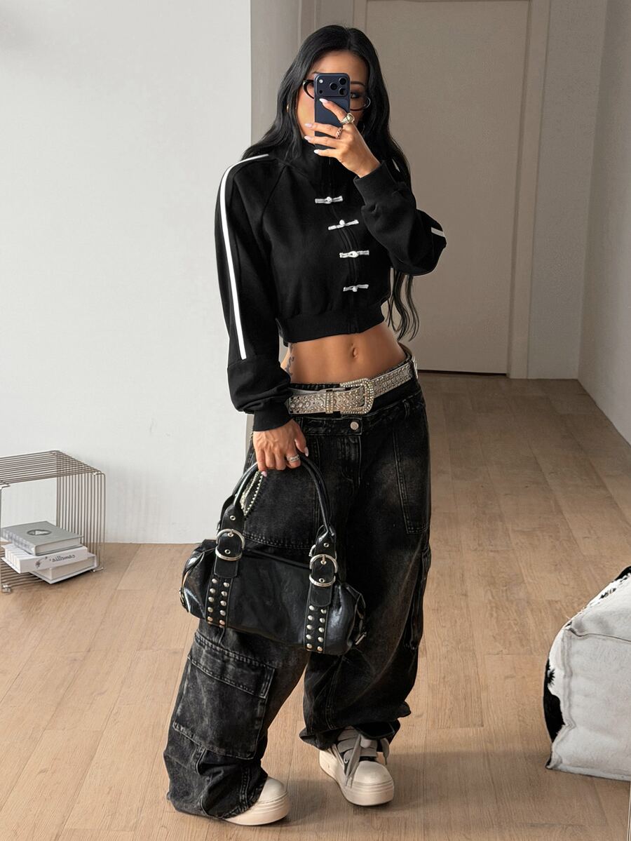 Women's black cropped track jacket with white colorblock tape details, stand collar, and front zip closure.