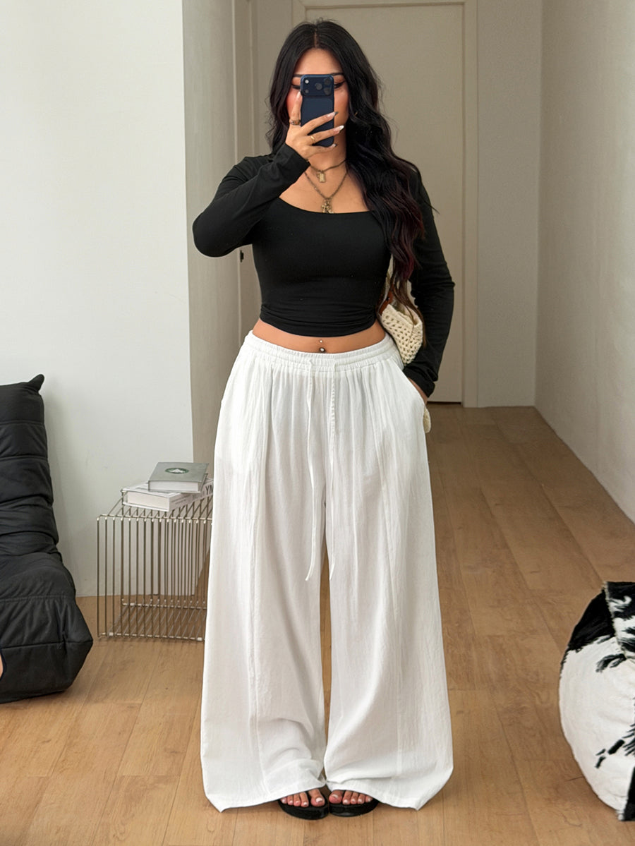 Women's loose straight leg cotton pants featuring a high waist with an adjustable drawstring knot and functional side pockets.