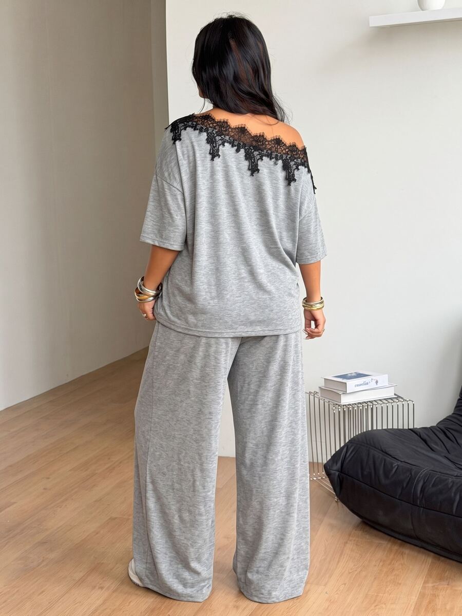 Women's casual two-piece outfit featuring a loose short-sleeve asymmetrical neck t-shirt and matching long wide leg pants with pockets.