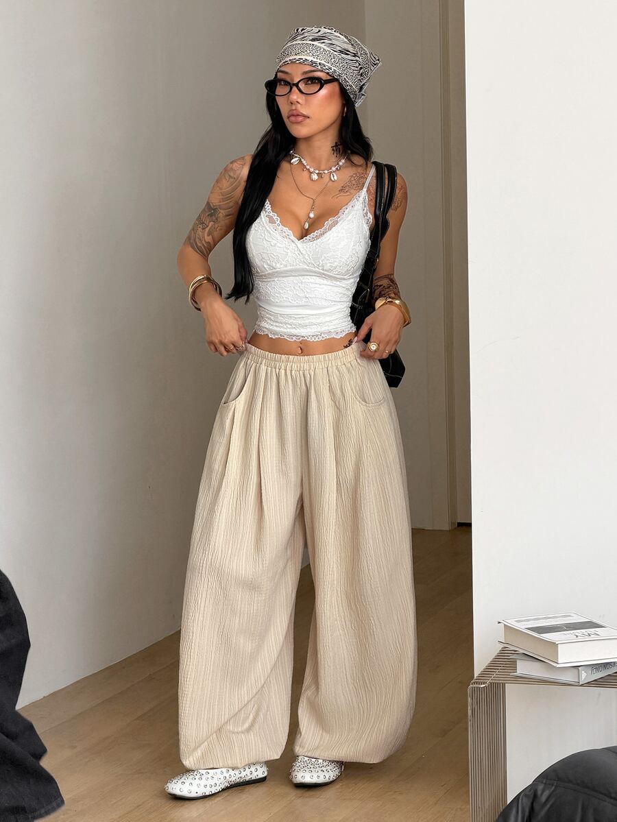 Women's loose-fit black bloomer pants made of 100% cotton featuring an elastic waistband and side pockets.
