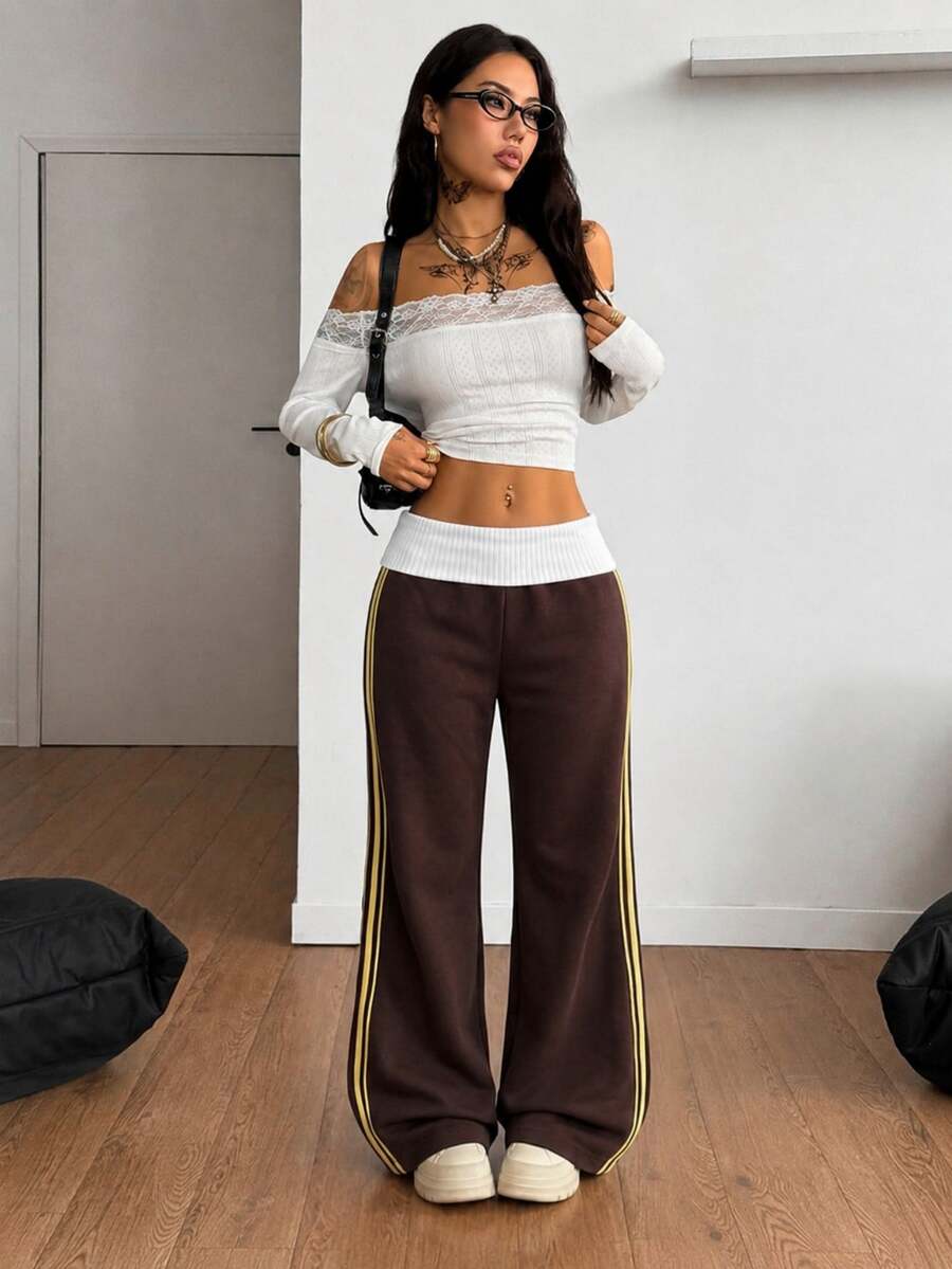 Women's wide leg flare sweatpants featuring a black and white colorblock contrast fold waistband and side stripe details.