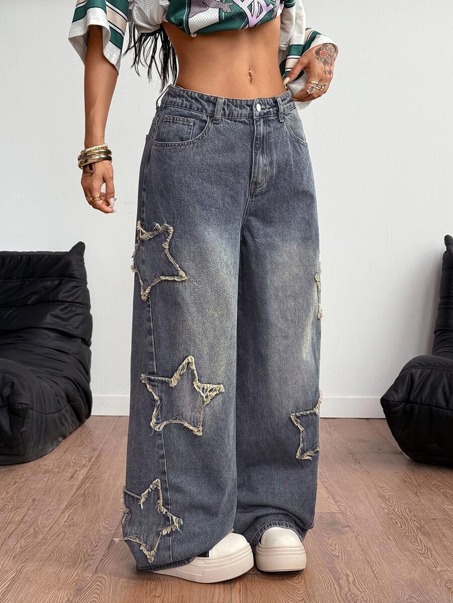 Women's loose fit baggy jeans in washed denim featuring star patches, slant pockets, and a mid-rise cut.