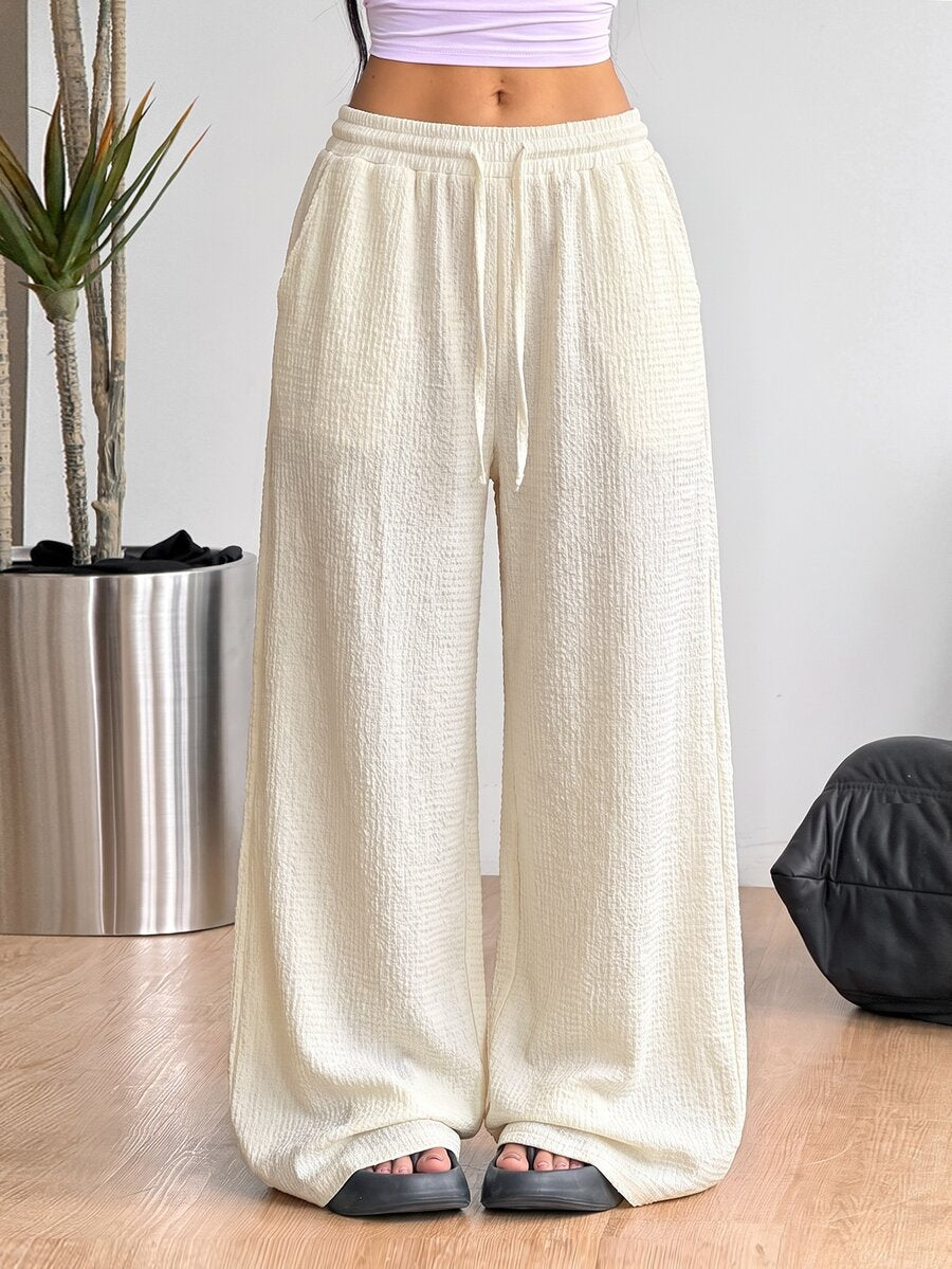 Women's loose fit straight leg lounge pants in textured knit fabric featuring an elastic drawstring waist and side pockets