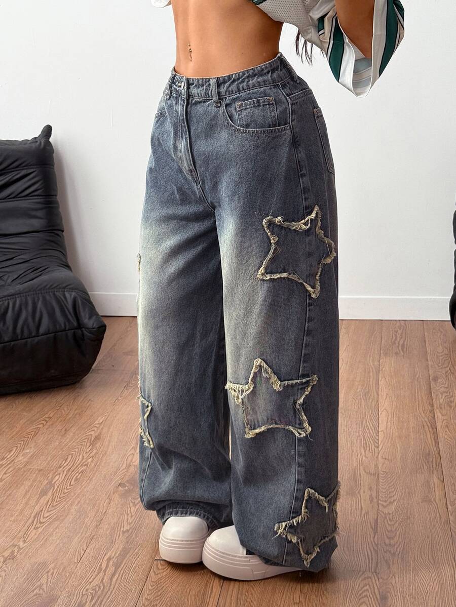 Women's loose fit baggy jeans in washed denim featuring star patches, slant pockets, and a mid-rise cut.