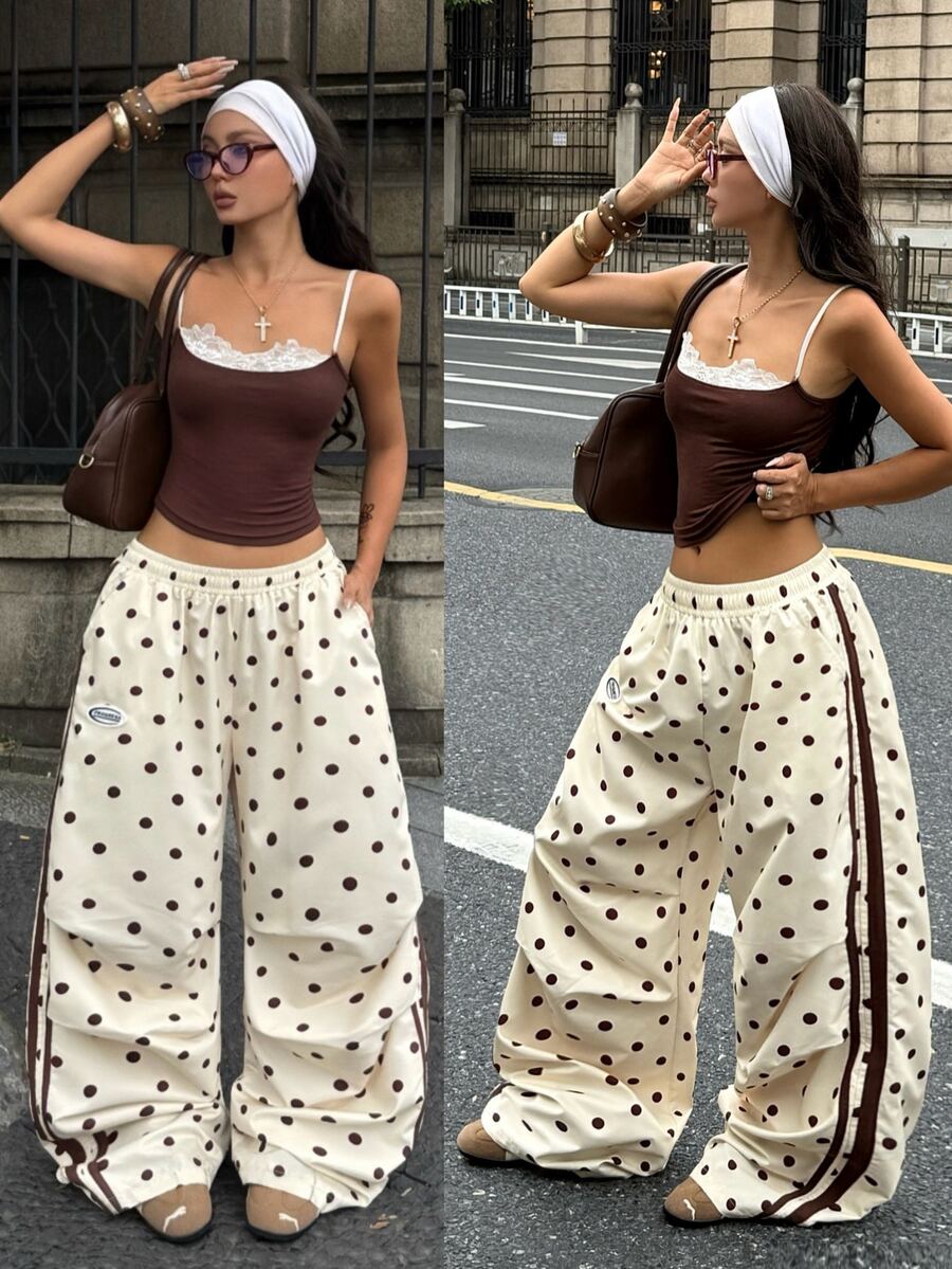 Women's black and white striped wide leg pants featuring an elastic drawstring waistband, side pockets, and a loose straight leg fit.