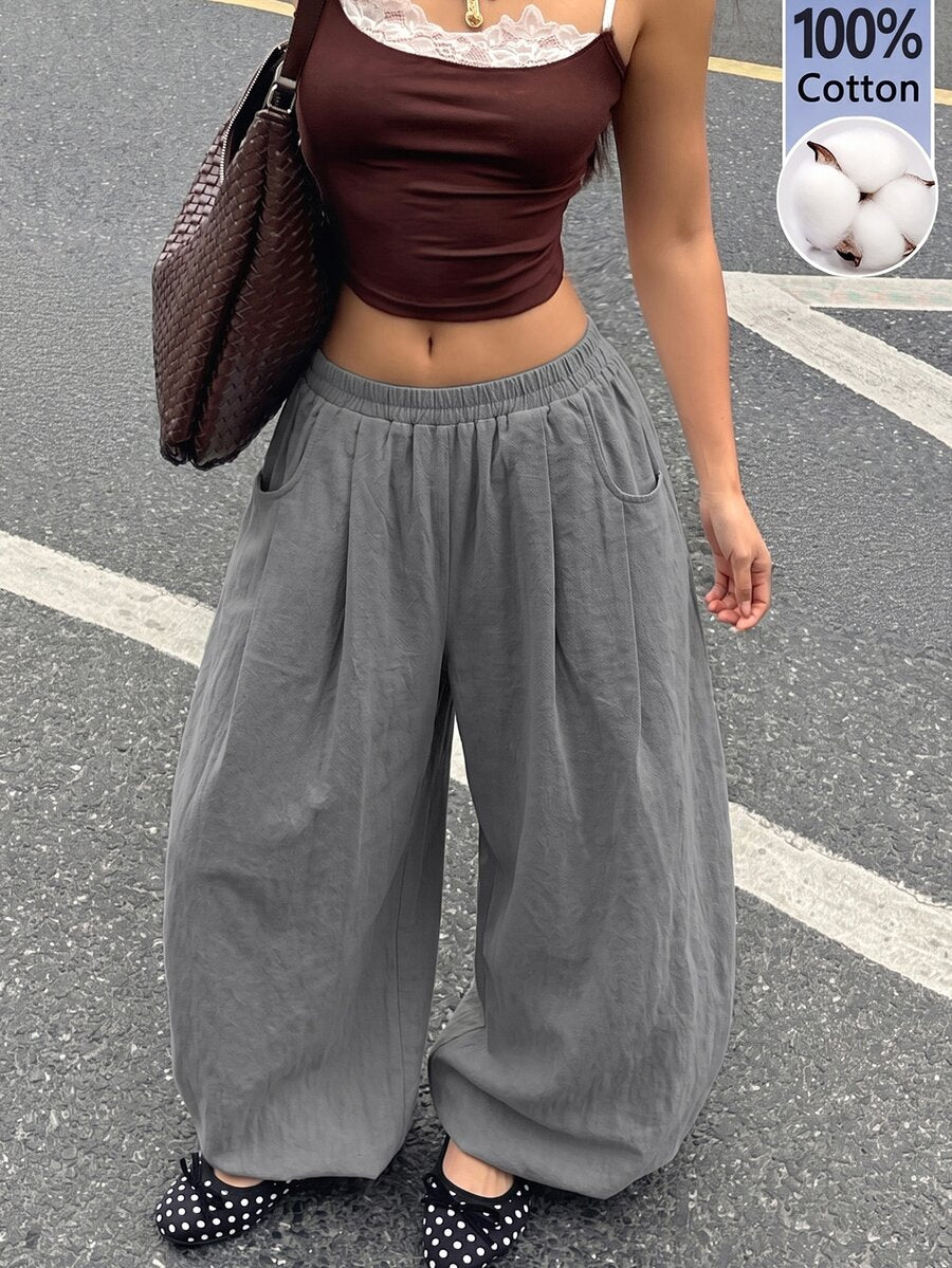Women's loose-fit black bloomer pants made of 100% cotton featuring an elastic waistband and side pockets.