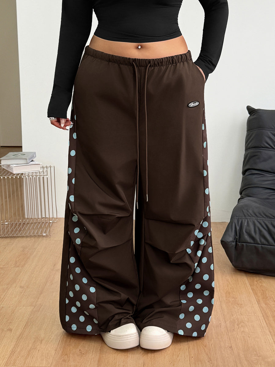 Women's high waist wide leg pants in black featuring leopard print patchwork details and an elastic drawstring waistband.