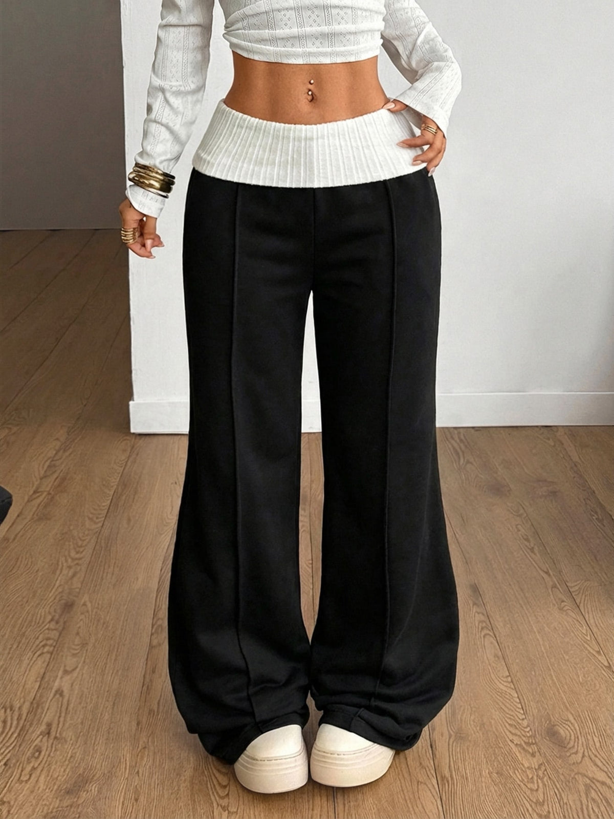 Women's wide leg flare sweatpants featuring a black and white colorblock contrast fold waistband and side stripe details.