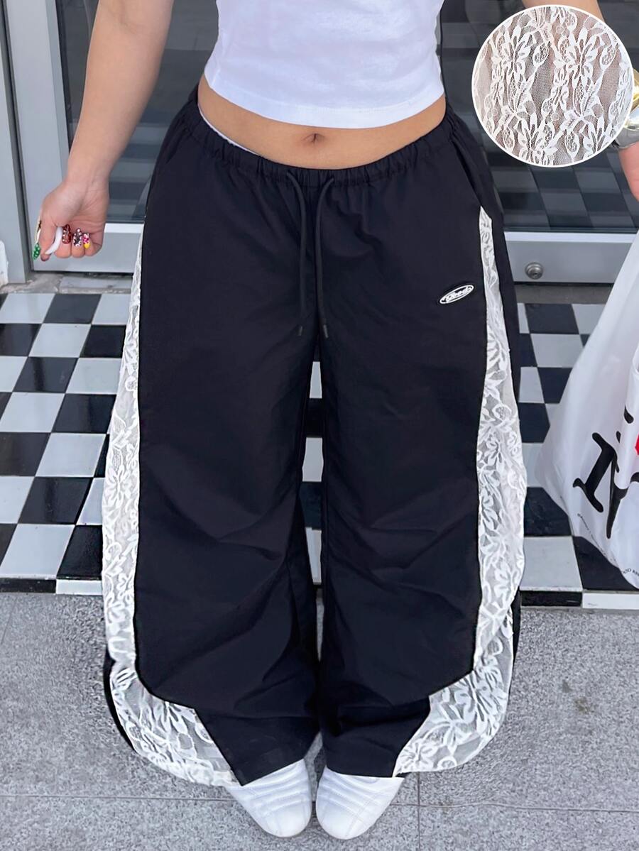 Women's high waist wide leg pants in black featuring leopard print patchwork details and an elastic drawstring waistband.