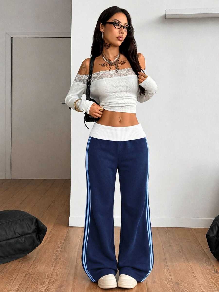 Women's wide leg flare sweatpants featuring a black and white colorblock contrast fold waistband and side stripe details.