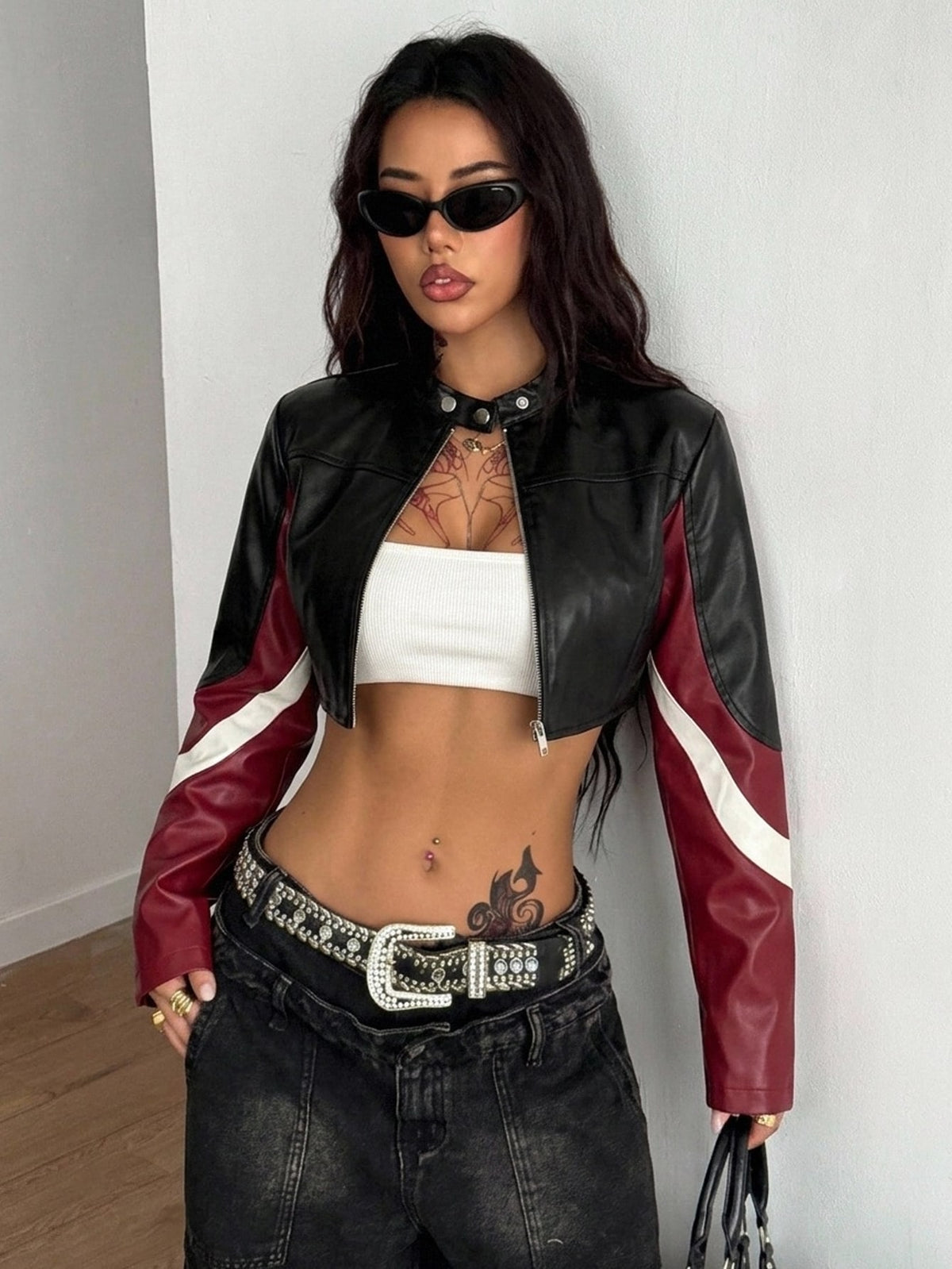 Front view of a women's black cropped PU leather jacket featuring a stand collar, long sleeves, and front zipper closure.