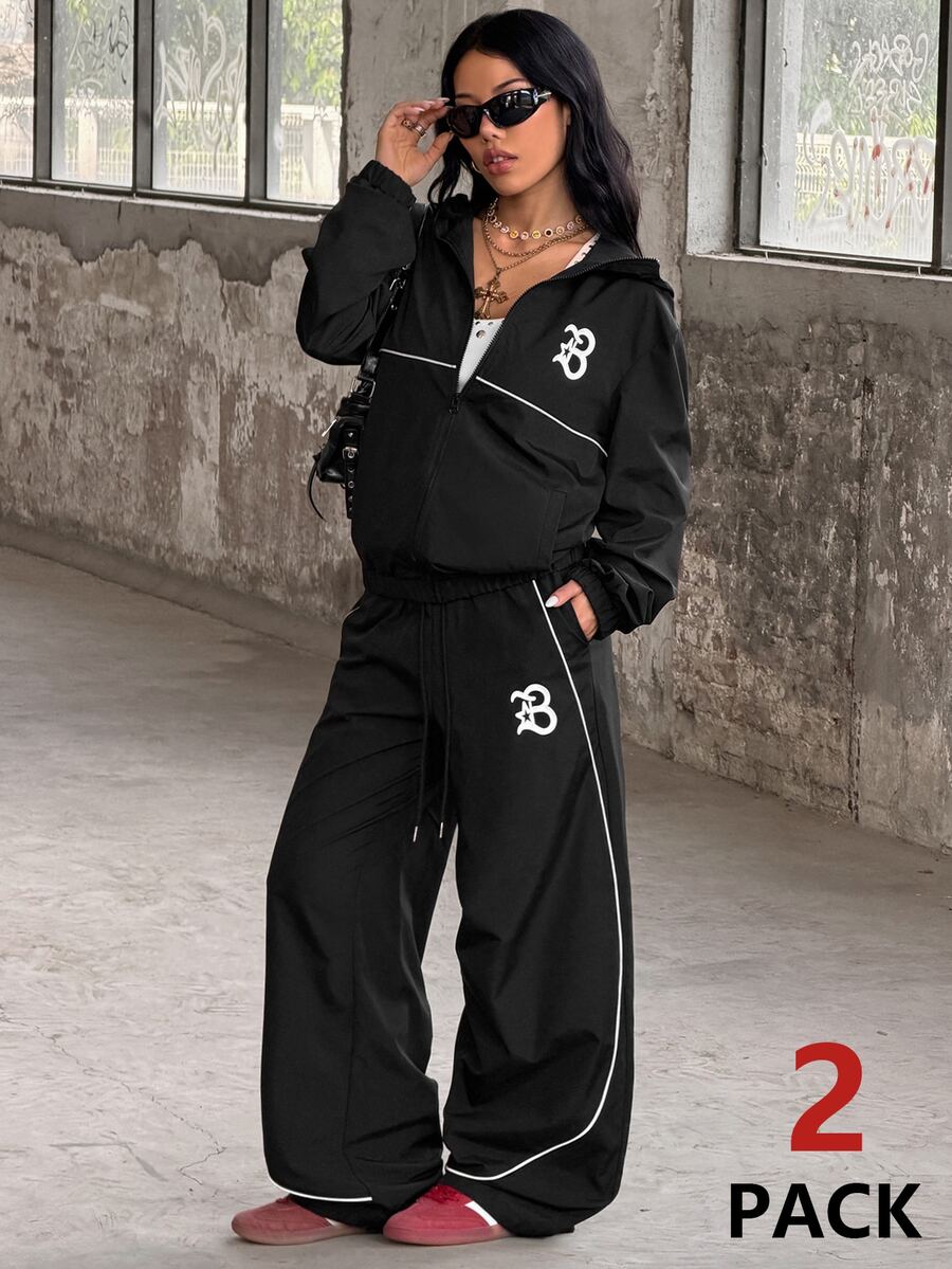 Two-piece black streetwear tracksuit set featuring a hooded windbreaker jacket with contrast piping and matching long jogger pants.