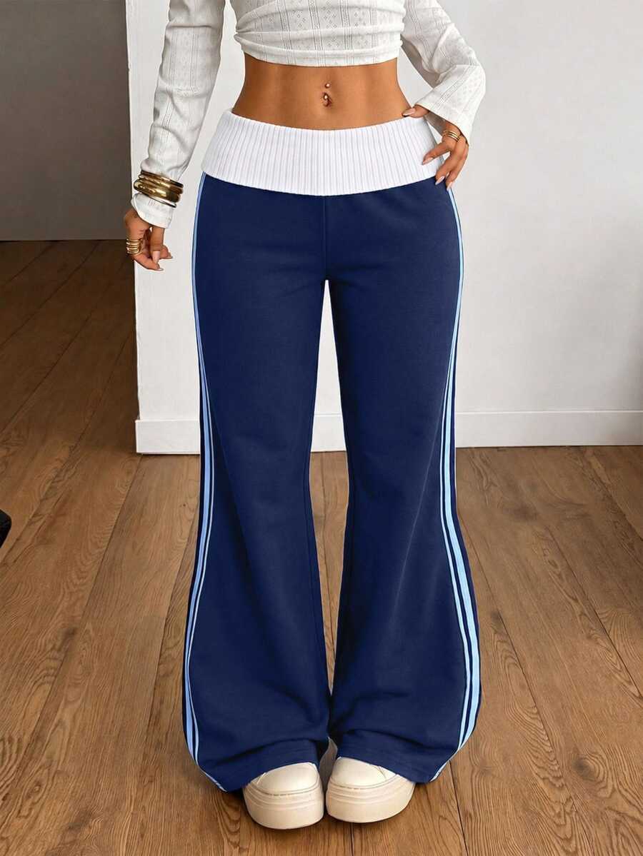 Women's wide leg flare sweatpants featuring a black and white colorblock contrast fold waistband and side stripe details.
