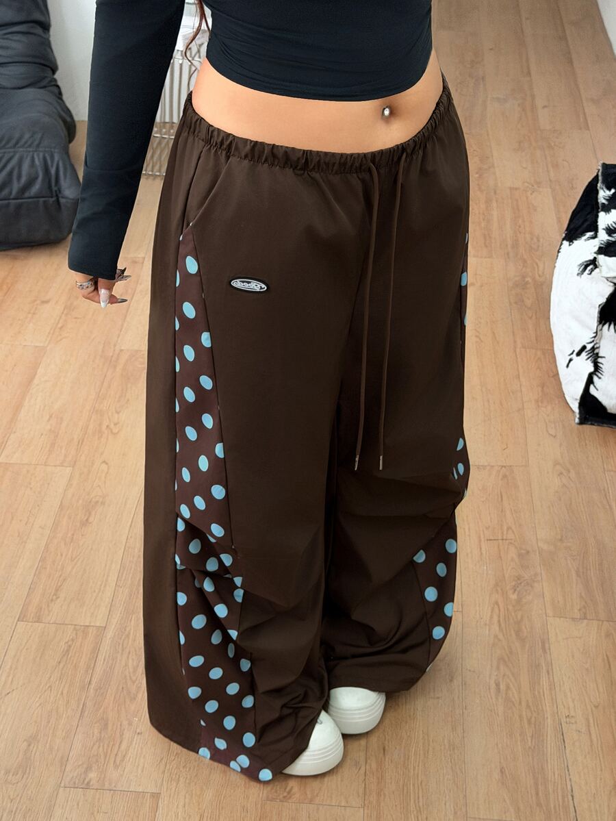 Women's high waist wide leg pants in black featuring leopard print patchwork details and an elastic drawstring waistband.