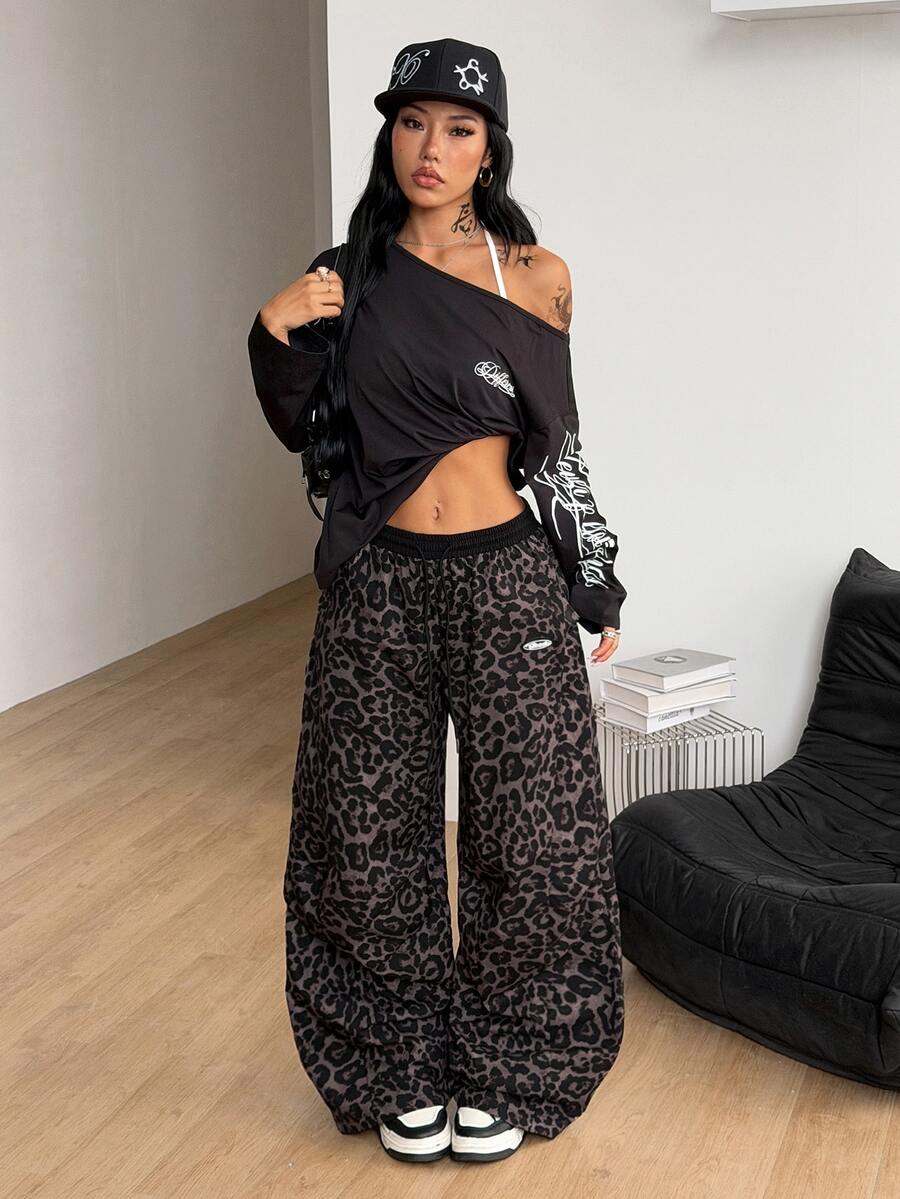 Women's black baggy jogger pants with an adjustable drawstring waist and colorblock polka dot geometric pattern.