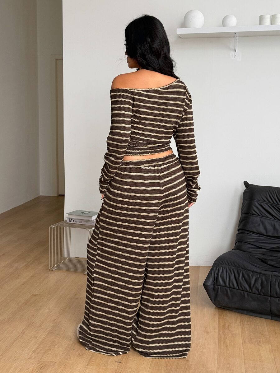 Women's two-piece outfit featuring a black and grey striped long-sleeve crop top with an asymmetrical neckline and coordinating wide-leg sweatpants.