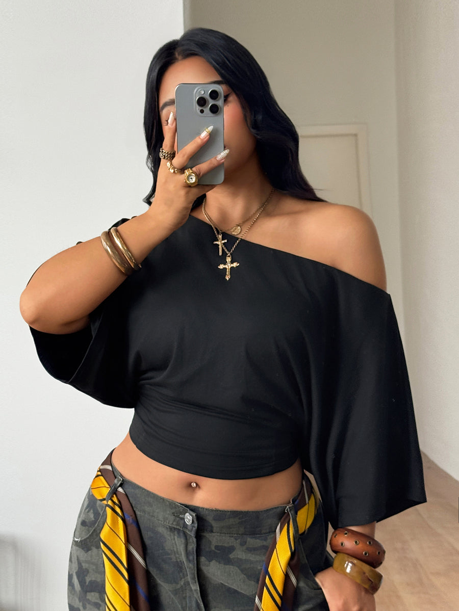 Black plus size cropped knit t-shirt featuring an asymmetrical scoop neckline, three-quarter batwing sleeves, and a loose casual fit.