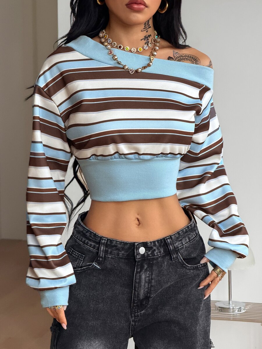 Baby pink off shoulder sweatshirt with asymmetrical neckline and long drop shoulder sleeves on a female model.