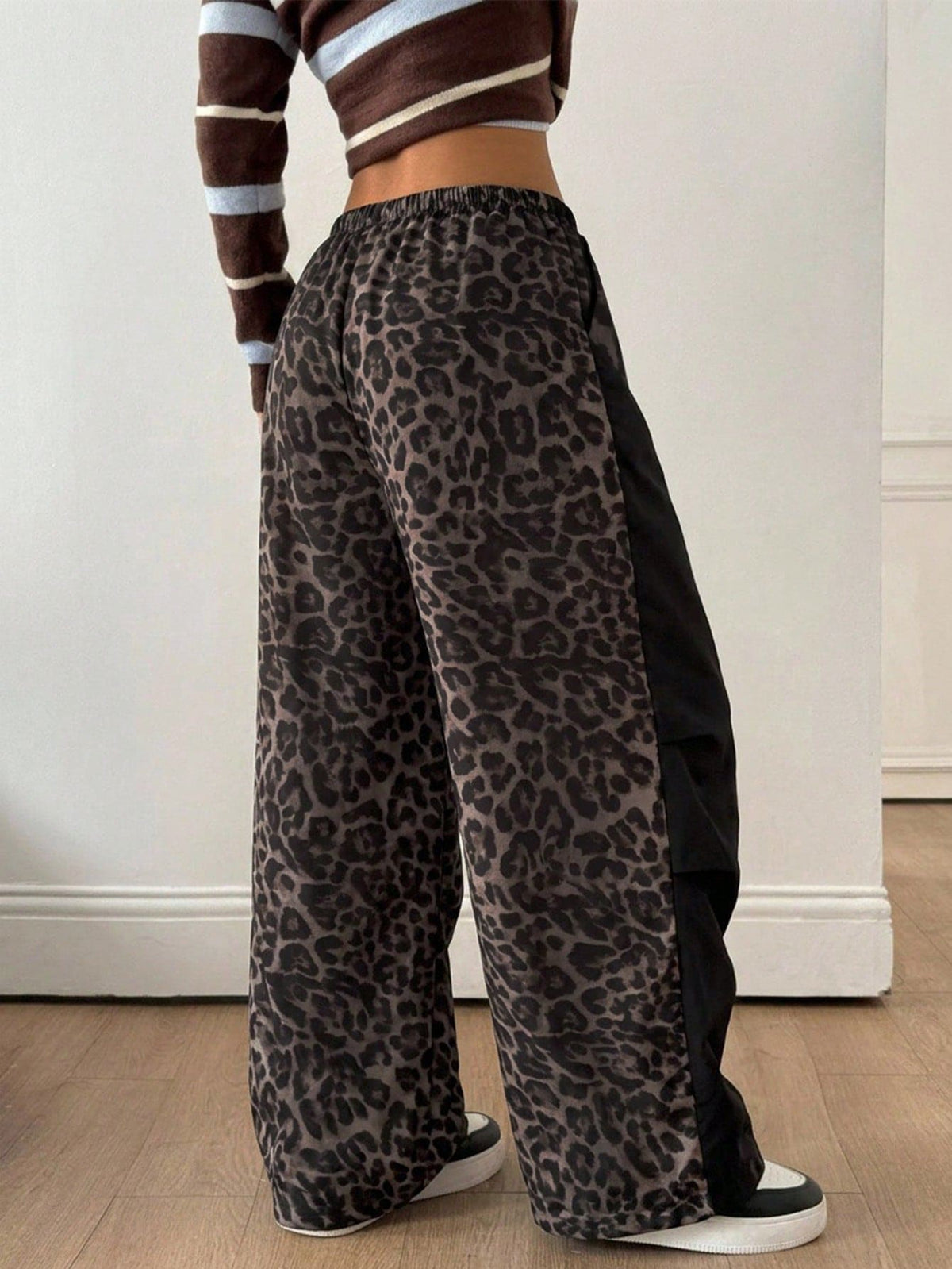 Women's black baggy jogger pants with an adjustable drawstring waist and colorblock polka dot geometric pattern.