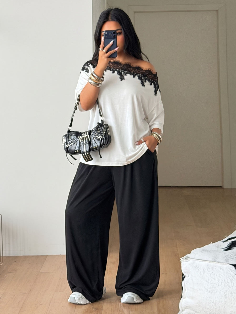 Women's casual two-piece outfit featuring a loose short-sleeve asymmetrical neck t-shirt and matching long wide leg pants with pockets.