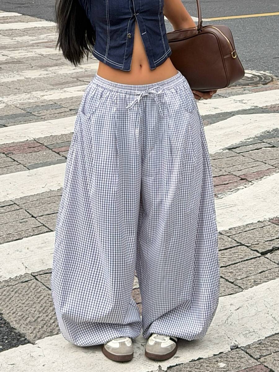 Women's loose-fit black bloomer pants made of 100% cotton featuring an elastic waistband and side pockets.