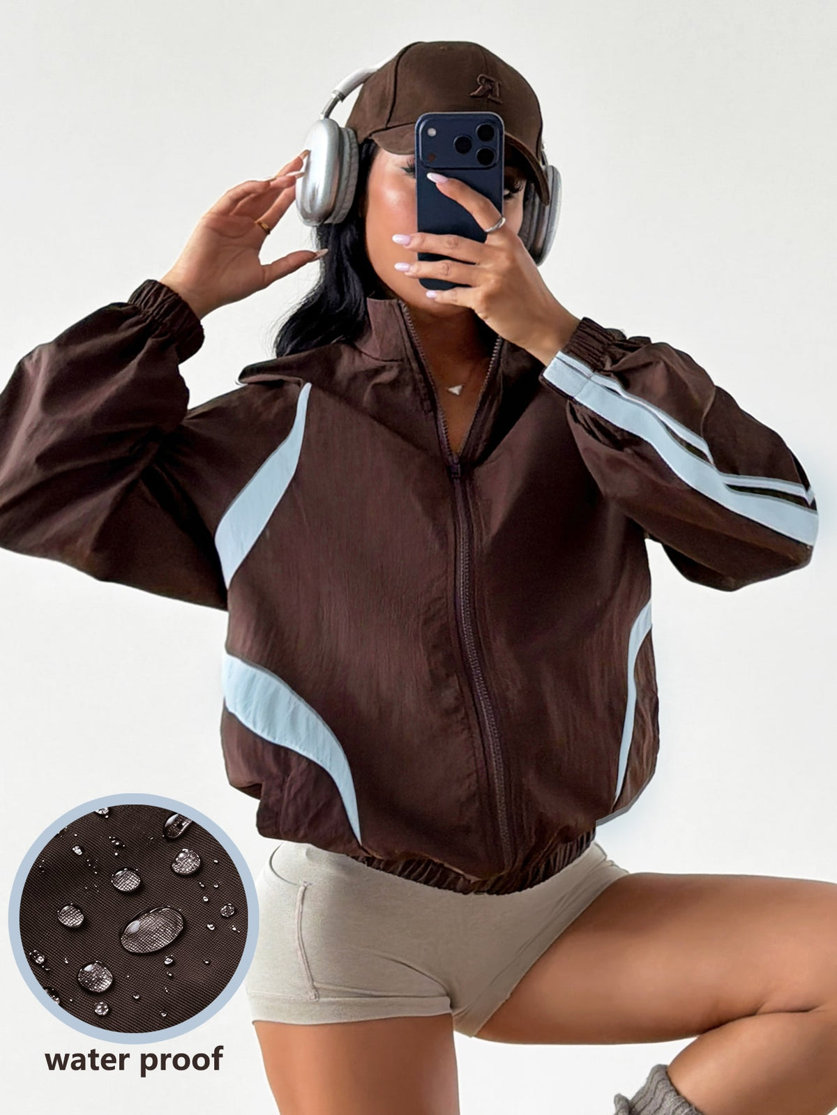 Front view of a women's oversized coffee brown sports jacket featuring a high neckline, front zipper closure, and long sleeves.