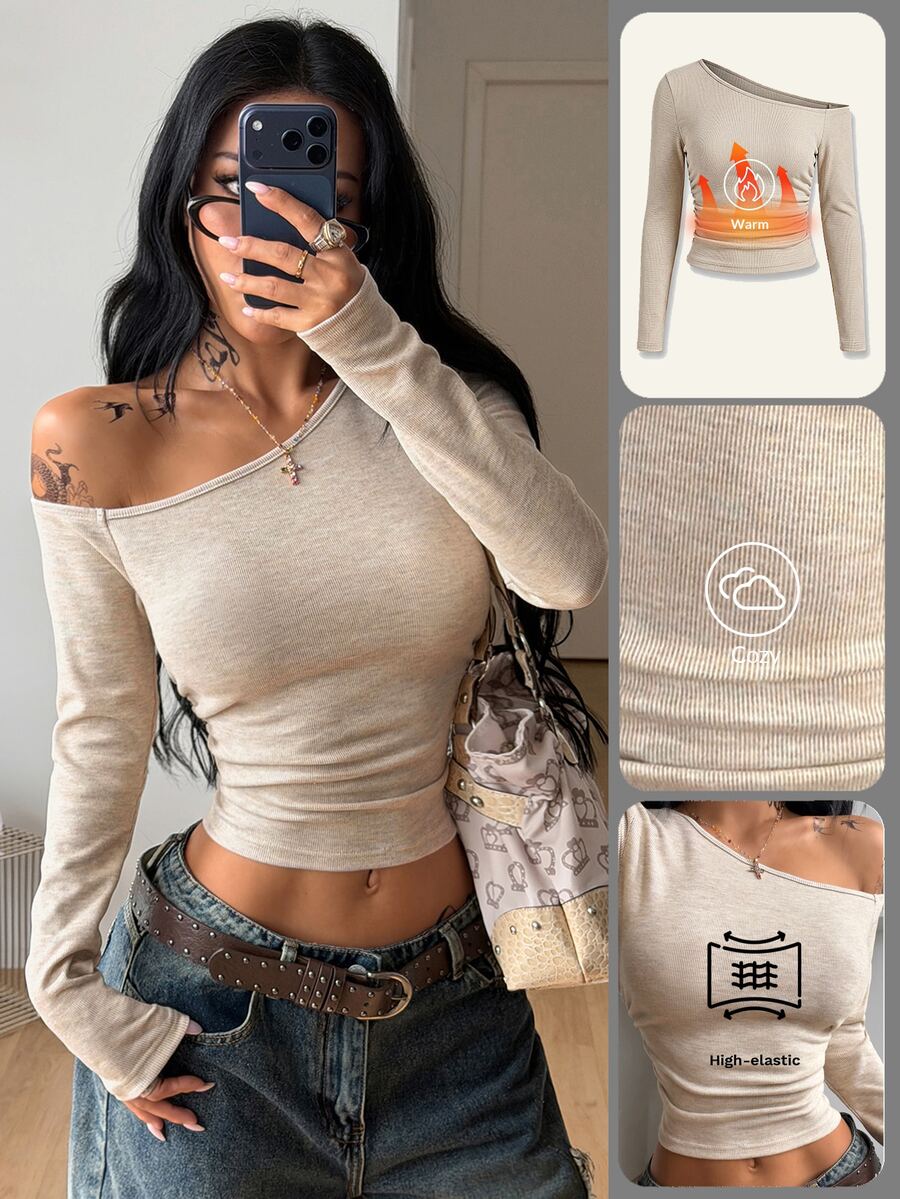 Women's slim fit long sleeve knit top featuring an asymmetrical neckline and grommet eyelet detail