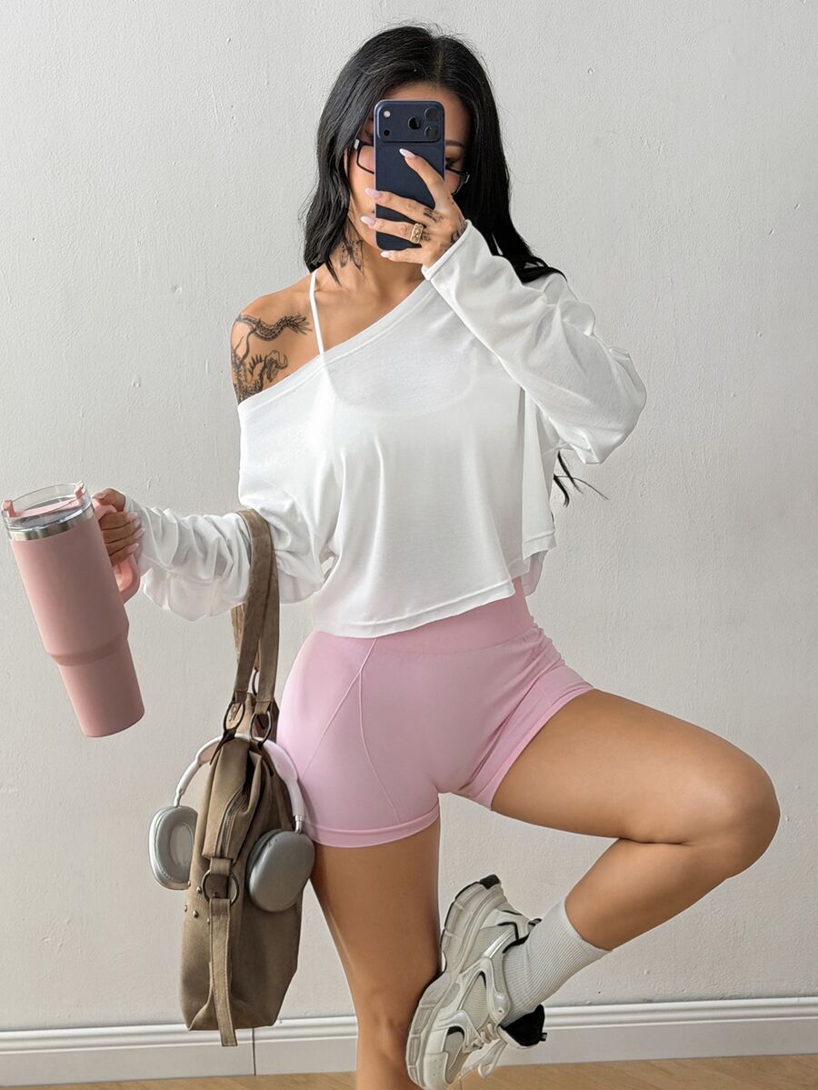 Women's white one shoulder rib-knit crop pullover top featuring an asymmetrical neckline, drop shoulder long sleeves, and a relaxed loose fit for yoga and athleisure wear.