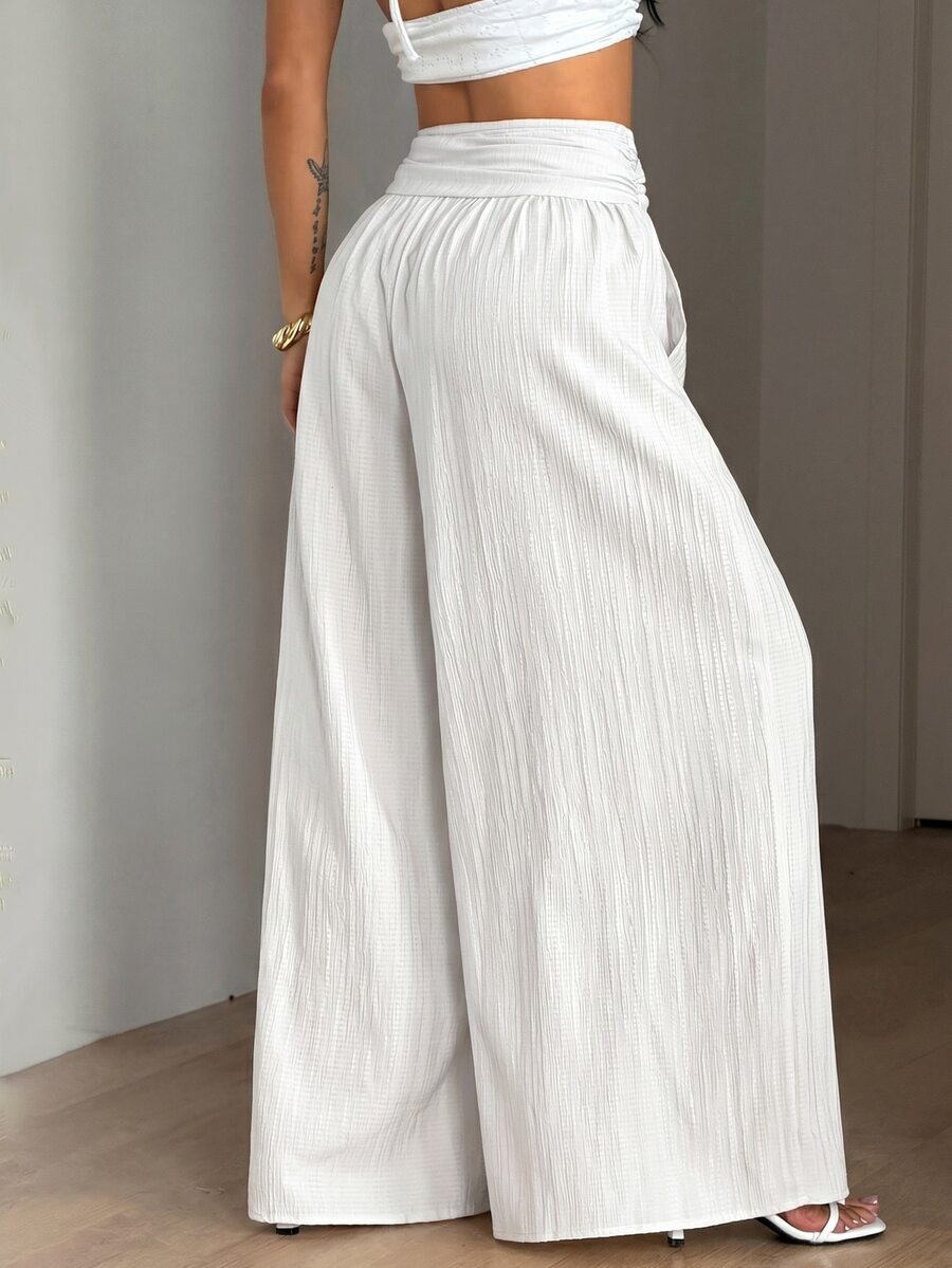 Women's plus size high-waist pleated wide leg pants in textured woven fabric with pockets
