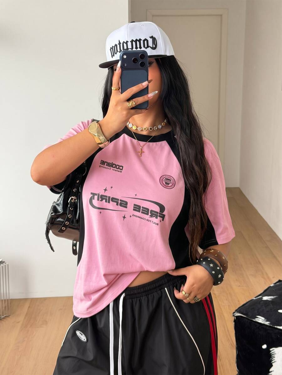 Unisex plus size oversized jersey t-shirt in brown featuring a round neck, short raglan sleeves with contrast binding, and a front letter graphic print.