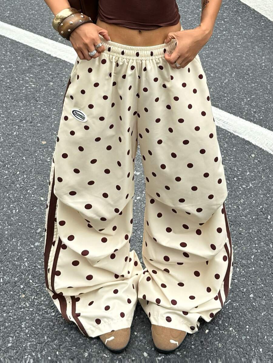 Women's black and white striped wide leg pants featuring an elastic drawstring waistband, side pockets, and a loose straight leg fit.