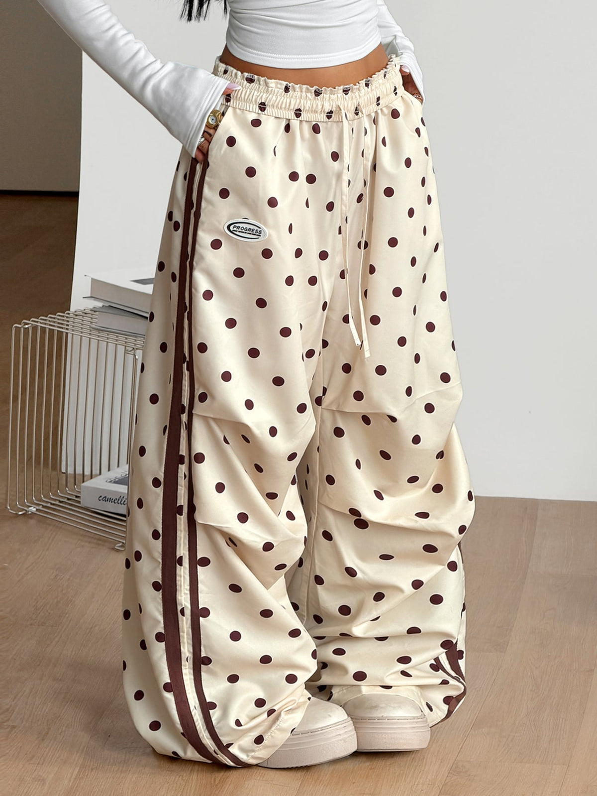 Women's black and white striped wide leg pants featuring an elastic drawstring waistband, side pockets, and a loose straight leg fit.