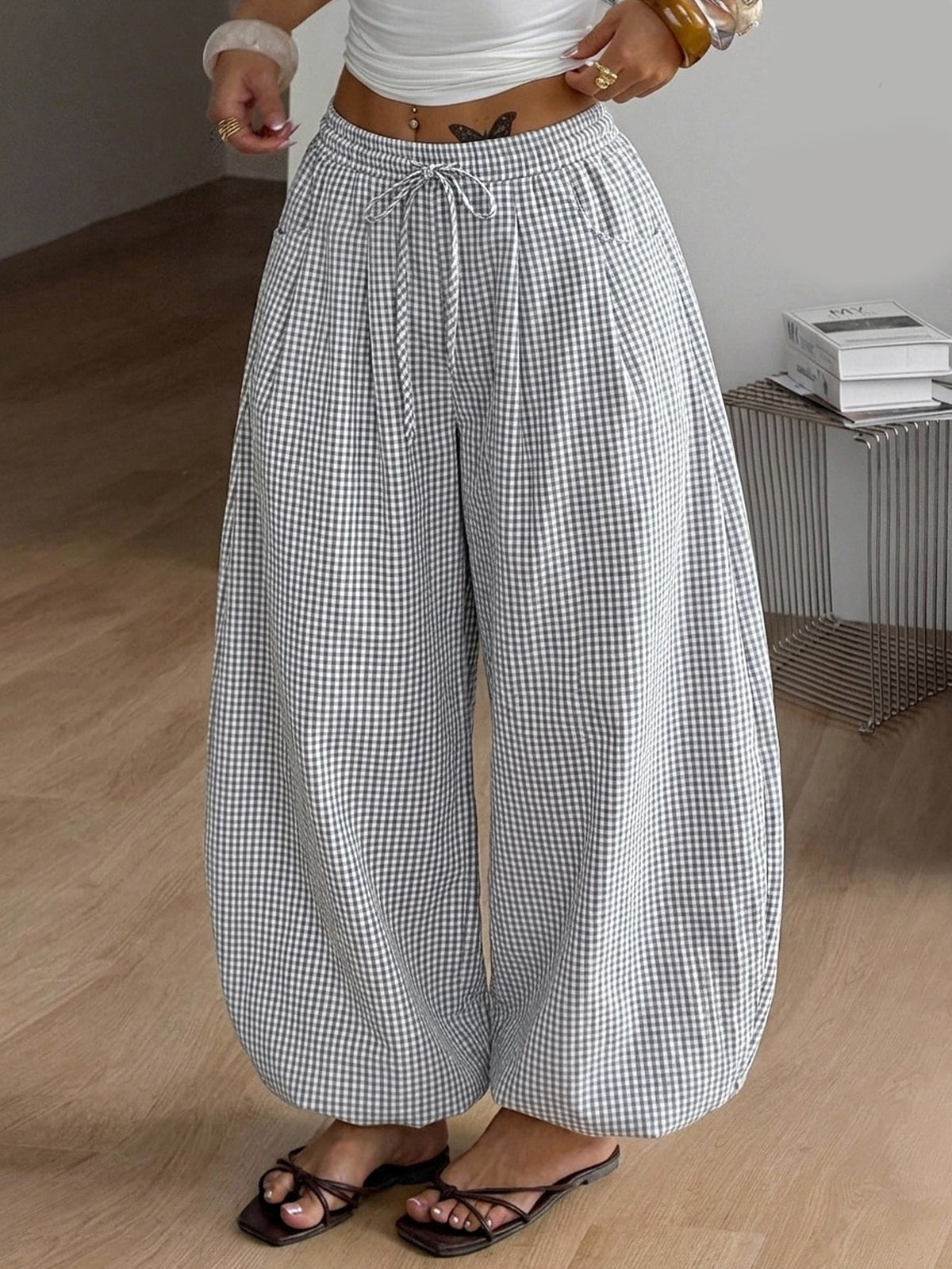 Women's loose-fit black bloomer pants made of 100% cotton featuring an elastic waistband and side pockets.