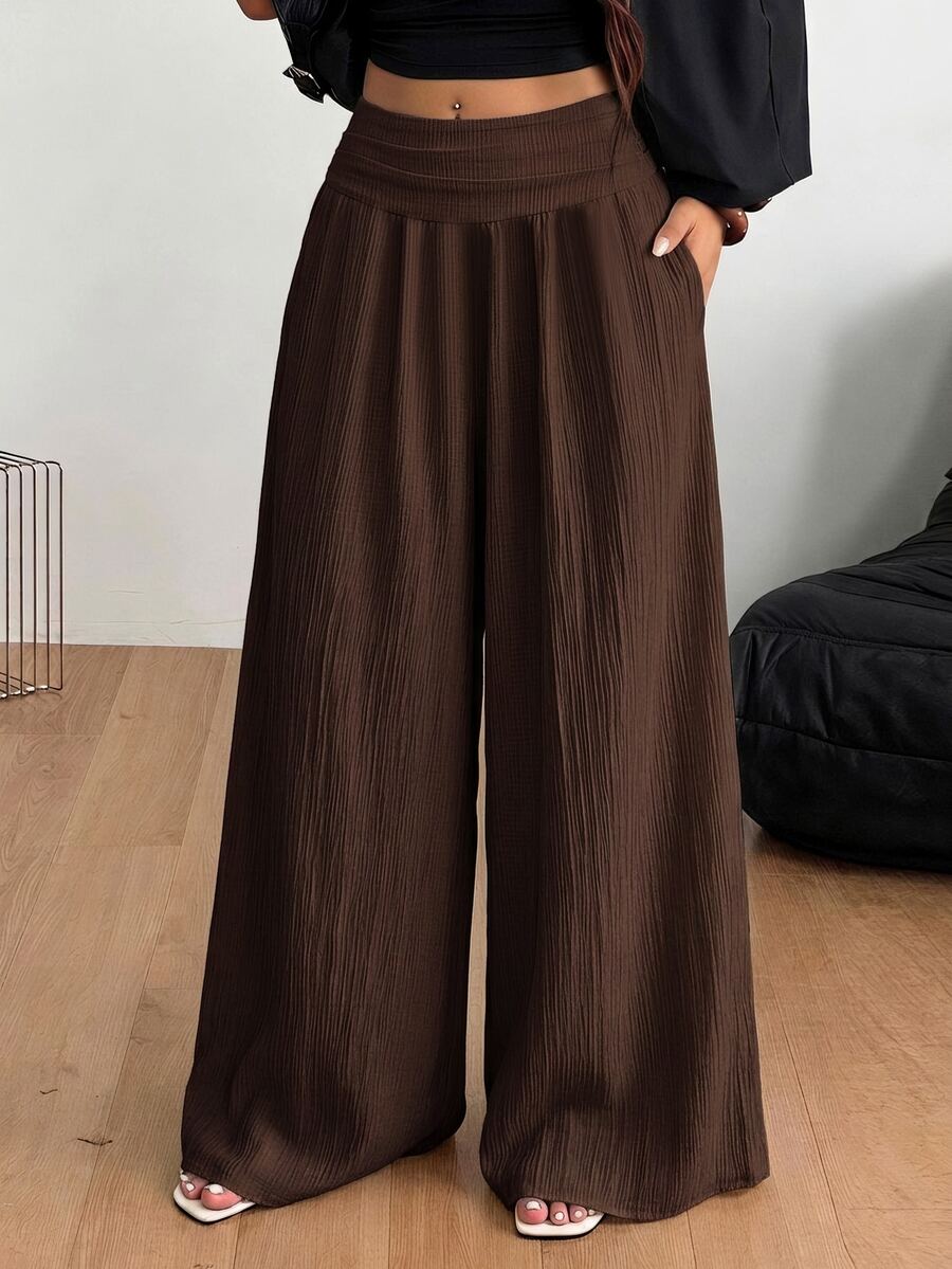Women's plus size high-waist pleated wide leg pants in textured woven fabric with pockets